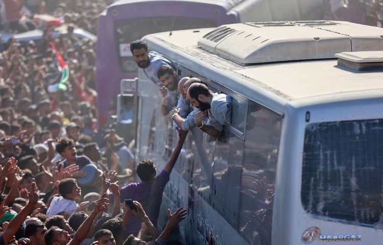 দখলদার ইসরাইলের কারাগার থেকে মুক্ত ফিলিস্তিনিদের বাসে করে নিয়ে যাওয়া হচ্ছে।